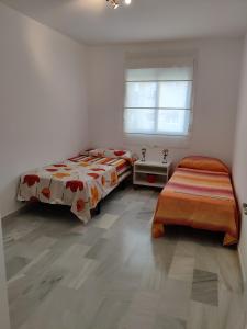 sypialnia z 2 łóżkami i oknem w obiekcie Apartamento Málaga Centro w Maladze