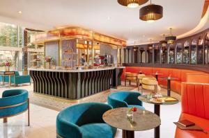 ダブリンにあるThe Grafton Hotelの赤と青の椅子とバーのあるレストラン