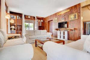 un soggiorno con mobili bianchi e pareti in legno di Villa Maravillas by Slow Villas a Playa de Palma