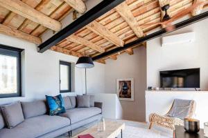 sala de estar con sofá y TV en Velo Vern 3 Luxury penthouse w views of city wall en Girona