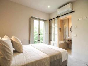 1 dormitorio con 1 cama grande y baño en Velo Vern 3 Luxury penthouse w views of city wall en Girona