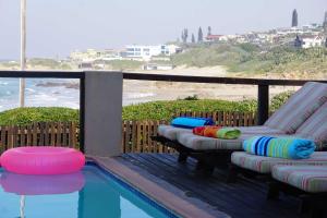 a pool with chaise lounges and a swimming pool with a beach at BillsBest Whaleback Cottage in Ramsgate