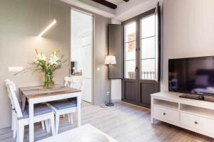 a living room with a dining table and a television at Sleep y Stay Home with balcony Bonaventura 3 in Girona