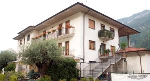 un grande edificio bianco con balconi e scale di Affittacamere La Martina a Vigano San Martino