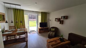 un soggiorno con TV, divano e tavolo di Lieblingsplatz im Küstenwald Graal-Müritz a Gelbensande