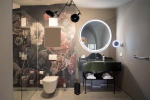 La salle de bains est pourvue d'un lavabo, d'un miroir et de toilettes. dans l'établissement Hotel Sonne, à Zittau