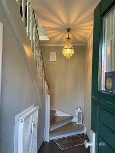 a hallway with a chandelier and stairs in a house at Haus in der Gartenstadt in Bottrop