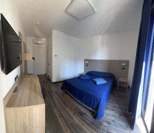 a bedroom with a blue bed and a blue wall at Tiby Hotel in Modena