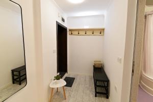 a hallway with a small table and a mirror at Sea apartment / Апартамент до морето in Varna City
