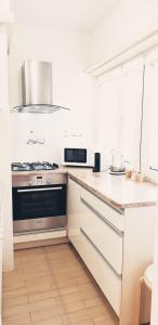 a white kitchen with a stove and a microwave at Studio City centre Lutomierska Manufaktura in Łódź