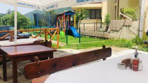 a park with a bench and a playground at Family Hotel Gorski Kut in Rilski Manastir