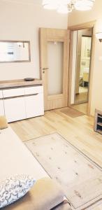 a living room with a wooden floor and a kitchen at Studio City centre Lutomierska Manufaktura in Łódź