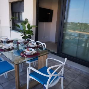 uma mesa de jantar e 2 cadeiras e uma mesa e cadeiras de vidro em Isla Canela -APARTAMENTO LOS FLAMENCOS em Isla Canela