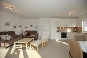 a living room with a couch and a table and chairs at Feriendorf Am Mariannenweg Reethaus 14b in Boltenhagen