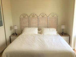 a white bed with two pillows and two lamps at Apartamento Plaza de Los Naranjos Marbella in Marbella