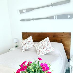 a bed with two pillows and flowers on it at B&B Le Bouganville in Lavagna