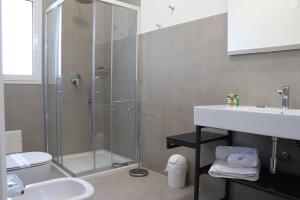 un bagno con doccia, WC e lavandino di Verde Blu Vacanze Suites a Porto Cesareo Altre 13 foto