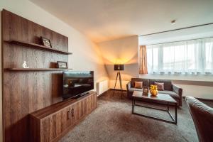 a living room with a couch and a television at Familienapartment Am Neumarkt l in Dresden +11 photos