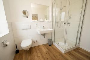 a bathroom with a shower and a toilet and a sink at Hotel Neumaier in Xanten