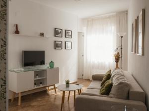 a living room with a couch and a tv at Apartamento Verdeo Córdoba Centro in Córdoba