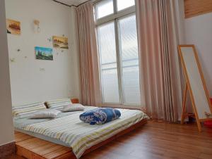 a bed in a room with a large window at 拉瓦宅 輕旅店 - Lawa House in Chiayi City