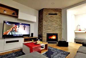 ein Wohnzimmer mit einem Kamin und einem Flachbild-TV in der Unterkunft Casa dos Henriques Gerês in Geres