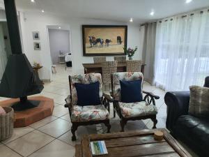 a living room with a couch and chairs and a table at Ukhozi House in Dullstroom