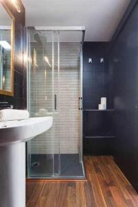 uma casa de banho com uma cabina de duche em vidro e um lavatório. em Apartamento para 4 con terraza privada en el centro em Girona