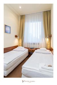 2 camas en una habitación de hotel con ventana en Hotel Colibra, en Varsovia