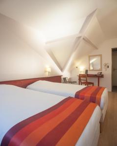 A bed or beds in a room at Hôtel Morphée Lille Villeneuve d'Ascq