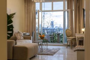 Una sala de estar con un sofá y una ventana grande. en Max Luxury Apartments, en Belgrado