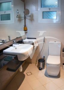 a bathroom with a sink and a toilet at Viola Hotel Apartments in Sharjah