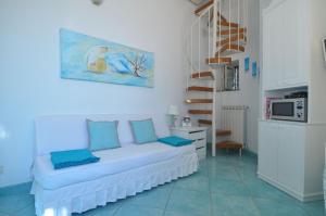 een woonkamer met een witte bank en blauwe kussens bij La Clarissa Amalfi Dreams in Ravello