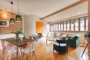 sala de estar con sofá verde, mesa y sillas en Sleep & Stay- Luxury top floor apt with terrace, en Girona