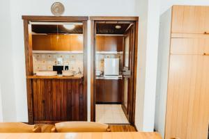 - une cuisine avec des placards en bois et un réfrigérateur dans l'établissement Liarets Furnished flat, à Chamonix-Mont-Blanc