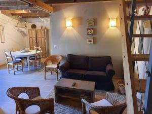 a living room with a couch and a table at Gîte de l'Ane Papillon-3 chb- piscine-jardin in Saint-Cirq-Souillaguet