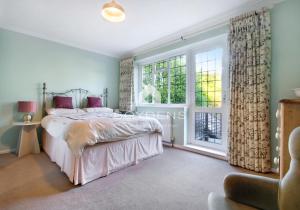 a bedroom with a bed and a large window at The Avenues, Frinton on Sea in Frinton-on-Sea