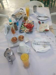 een witte tafel met borden eten en drinken bij Katafygio Die zuflucht in Marathias