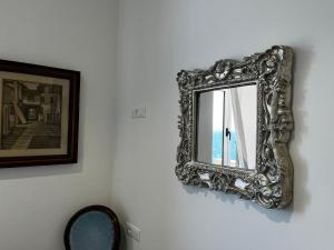 a mirror hanging on a wall next to a picture at Villa Tergeste in Trieste