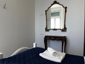 a bedroom with a bed with a mirror on the wall at Villa Tergeste in Trieste