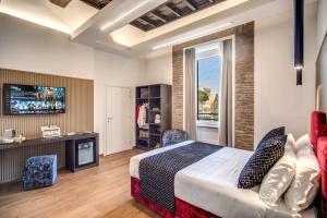 a bedroom with a bed and a tv and a couch at Little Queen Suite in Rome