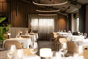 een eetkamer met witte tafels en stoelen bij Himmerland Resort Cottages in Farsø