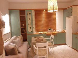 a kitchen and living room with a table and a couch at Amalthea Guest House in Kos