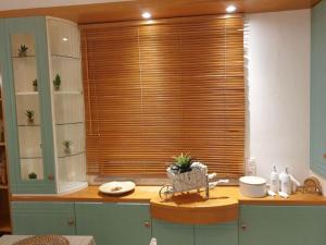 a kitchen with a window with wooden blinds at Amalthea Guest House in Kos