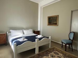 a bed in a room with a chair and a bed sidx sidx sidx at Villa Tergeste in Trieste