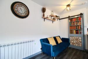 a living room with a blue couch and a clock on the wall at Alfriston Lodge By Air Premier in Alfriston