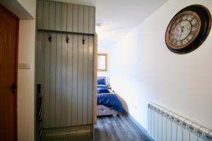 een slaapkamer met een klok aan de muur naast een bed bij Alfriston Lodge By Air Premier in Alfriston