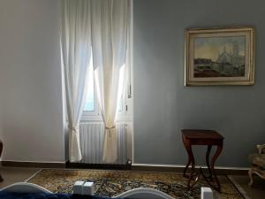 a room with a window with white curtains and a table at Villa Tergeste in Trieste