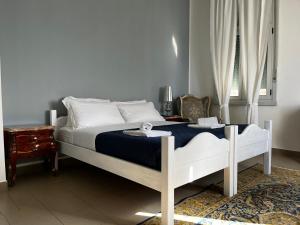 a bedroom with a white bed with a blue blanket at Villa Tergeste in Trieste