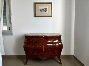 a wooden dresser in a room with a picture on the wall at Villa Tergeste in Trieste